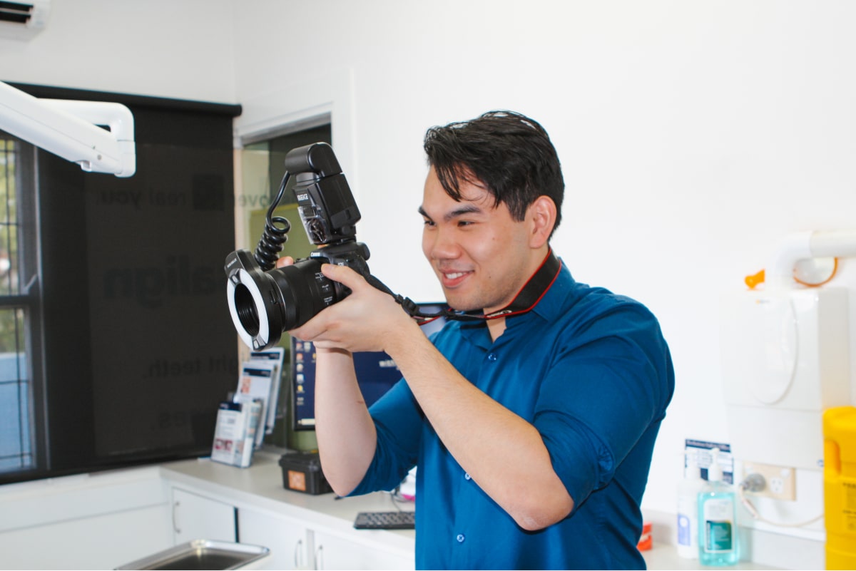 Man in dentist office taking pictures with camera